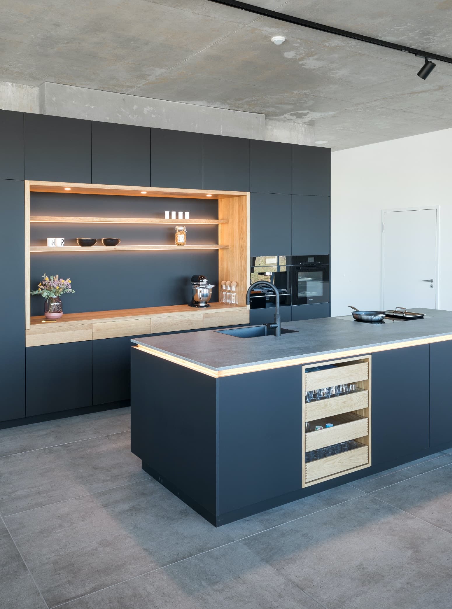Schwarze Designküche mit Echtholzelementen und modernster Ausstattung