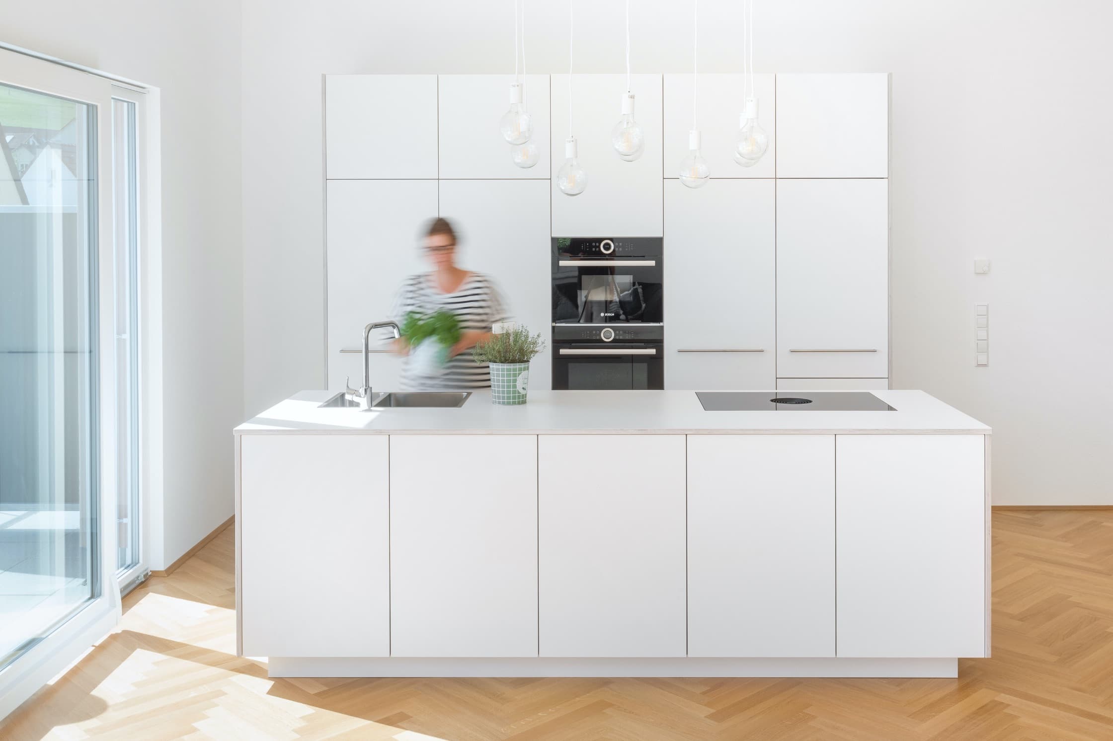 Minimalistische helle Küche mit versteckten Highlights