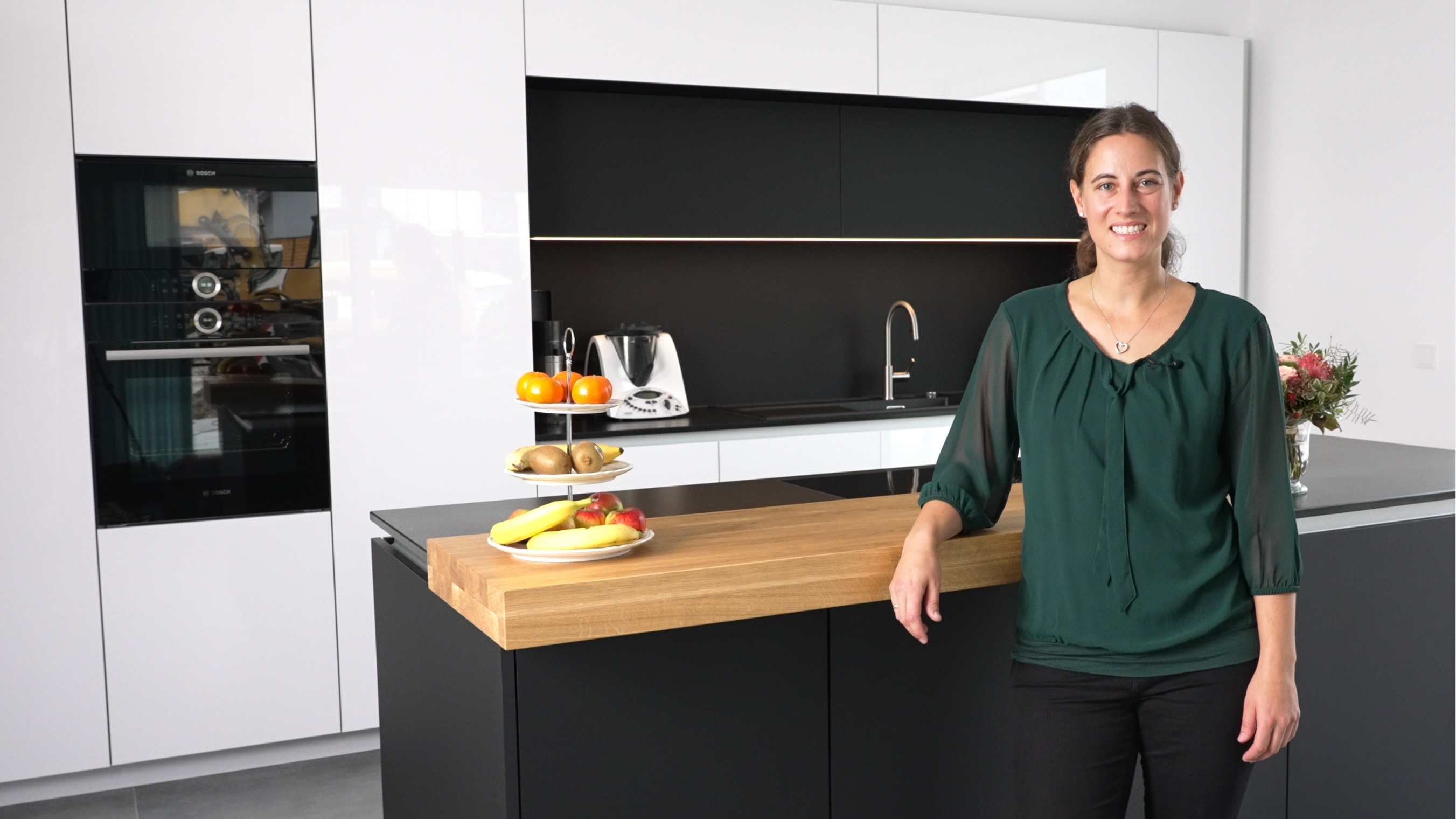 Carmen aus Schwäbisch Hall in ihrer weißen Küche mit schwarzer Kücheninsel von NR Küchen