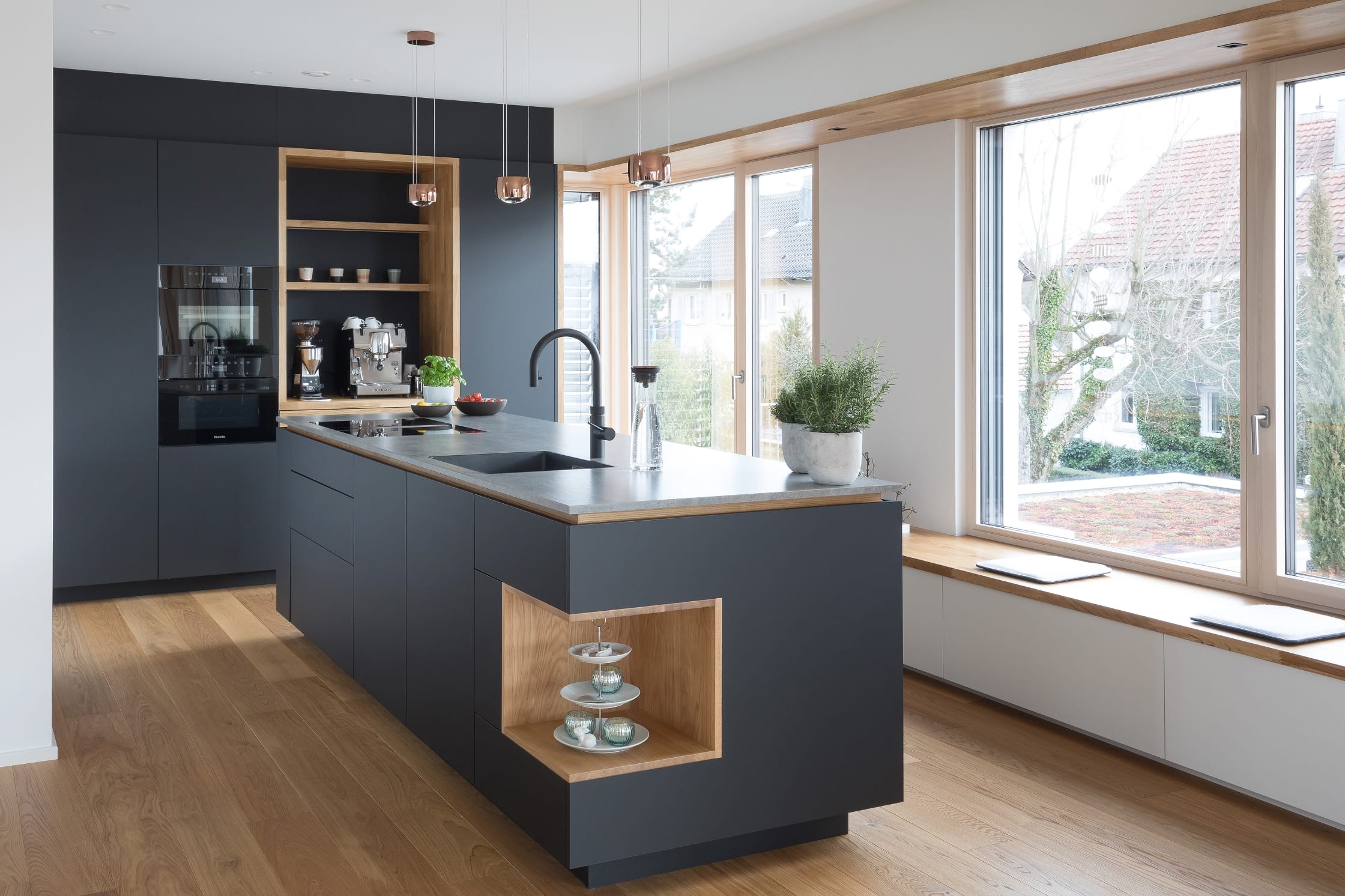 Schwarze Küchenzeile mit schwazer Kücheninsel und großer Fensterfront